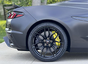 The back end of a sports car that's covered in a vinyl wrap
