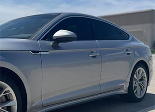 Dark window tint covers the side and front windows of a car