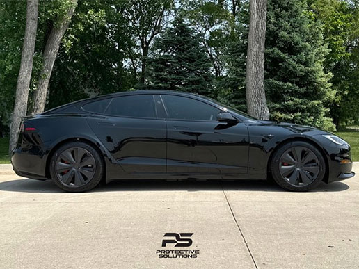 An all-black car with black hubcaps and dark window tint